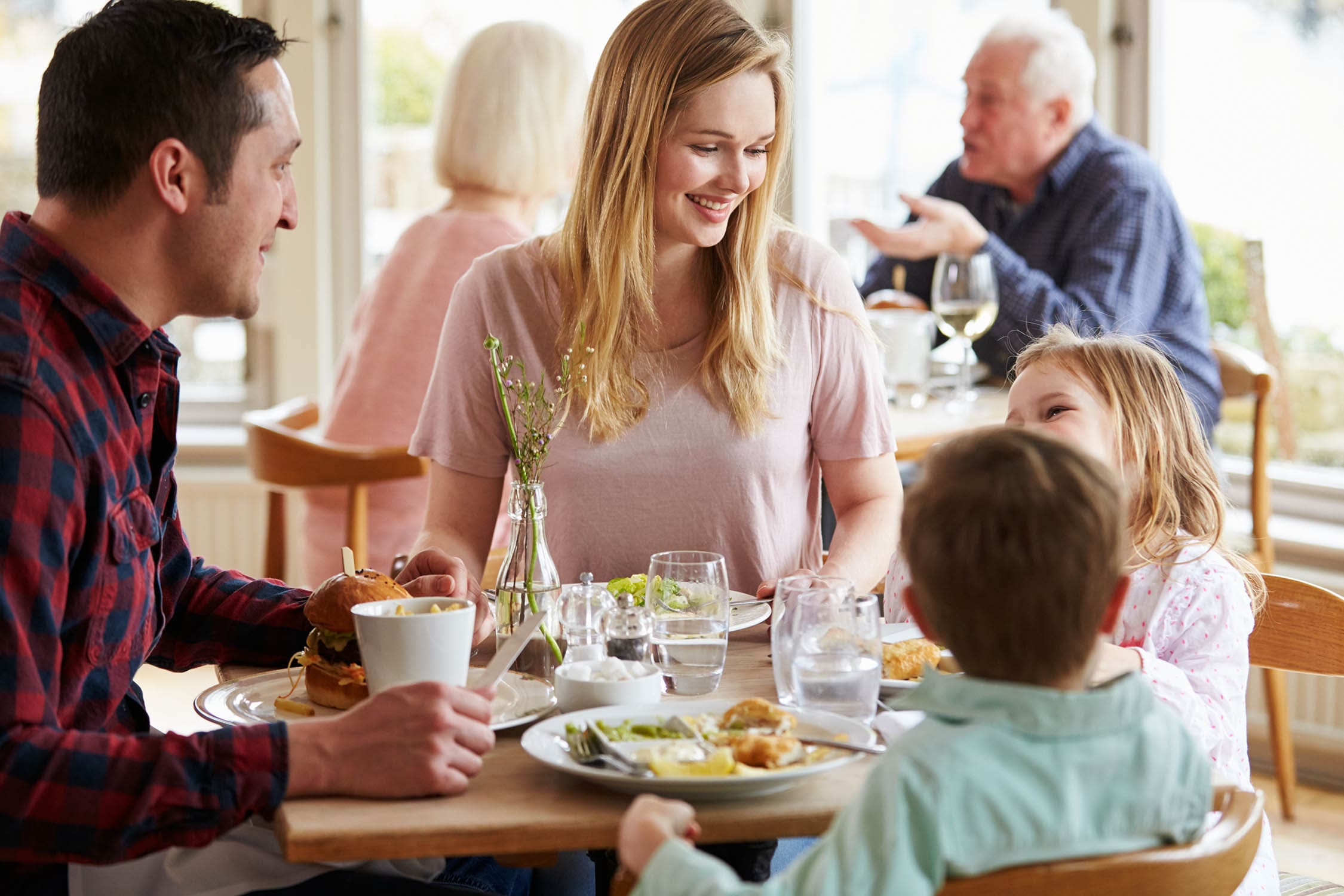 Lively restaurant with happy diners enjoying delicious meals.